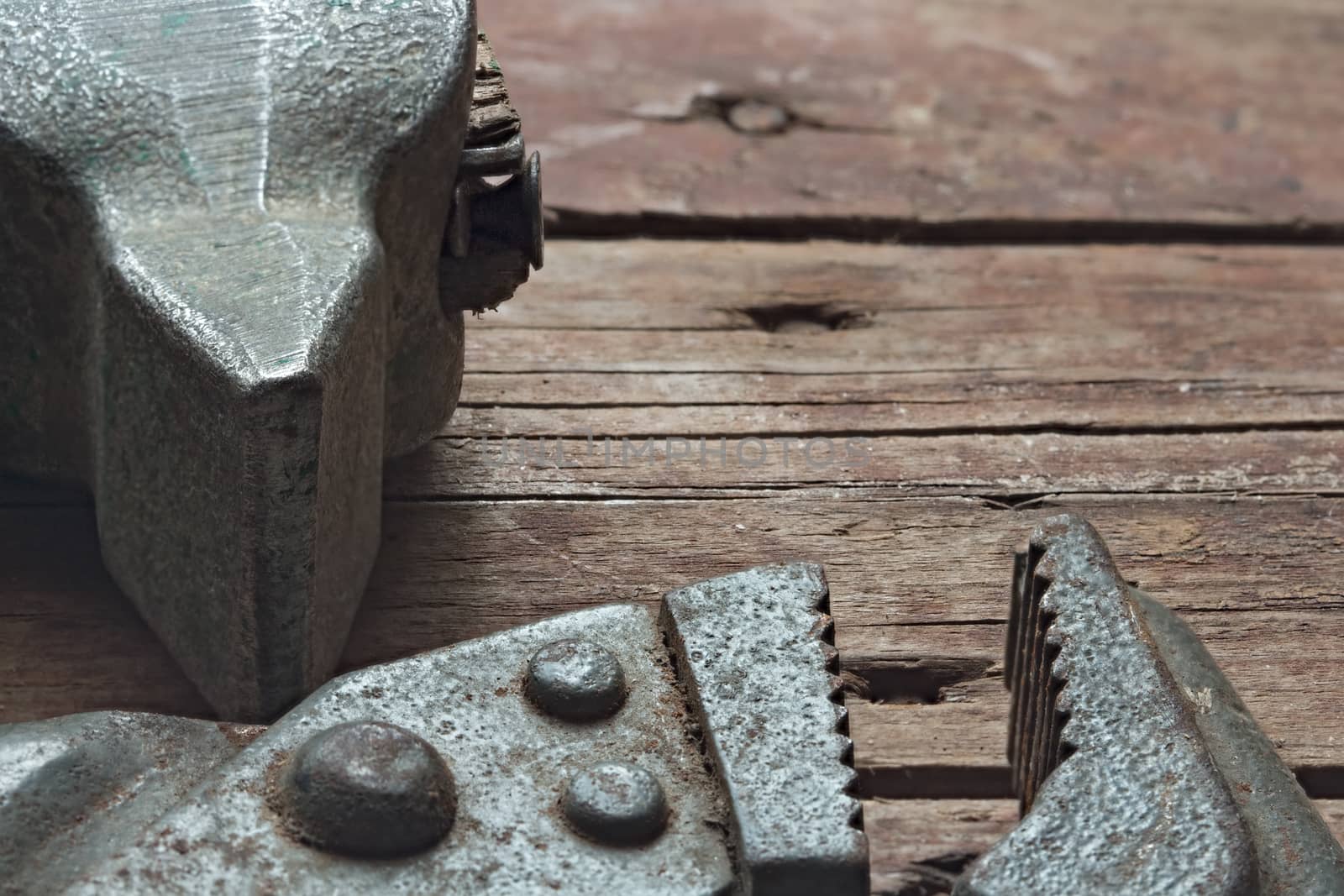 Hammer and adjustable wrench and  on a rough wooden background. Still life: old tools with traces of use and rust. Closeup selective focus image with copyspace.