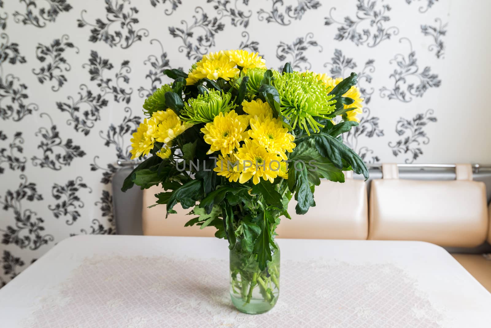 Bouquet of yellow and green chrysanthemums standing on kitchen table by olgavolodina