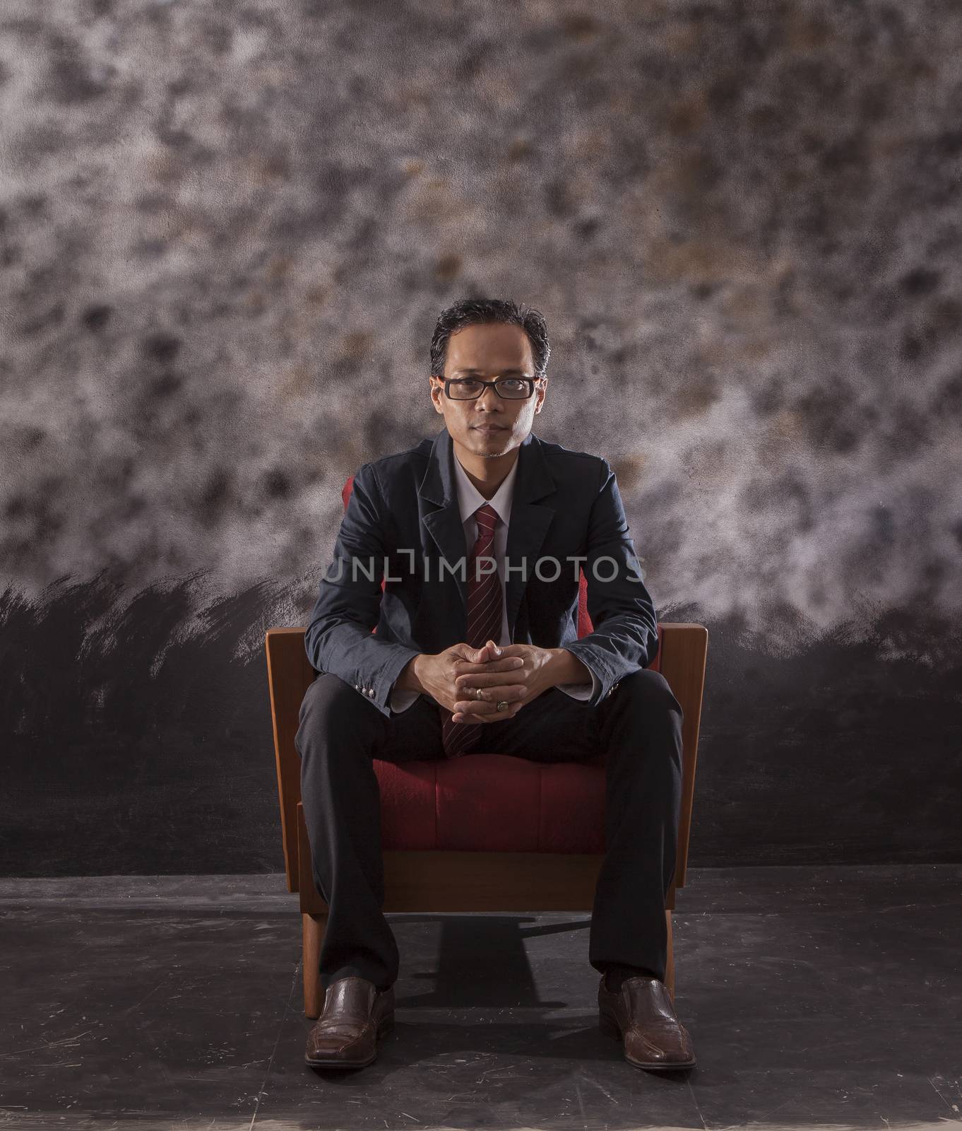 portrait of asian younger man sitting on old wood patio looking  by khunaspix