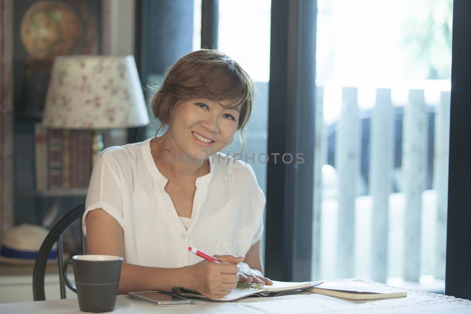 asian woman smiling face ,education and working at home concept relaxing on working table