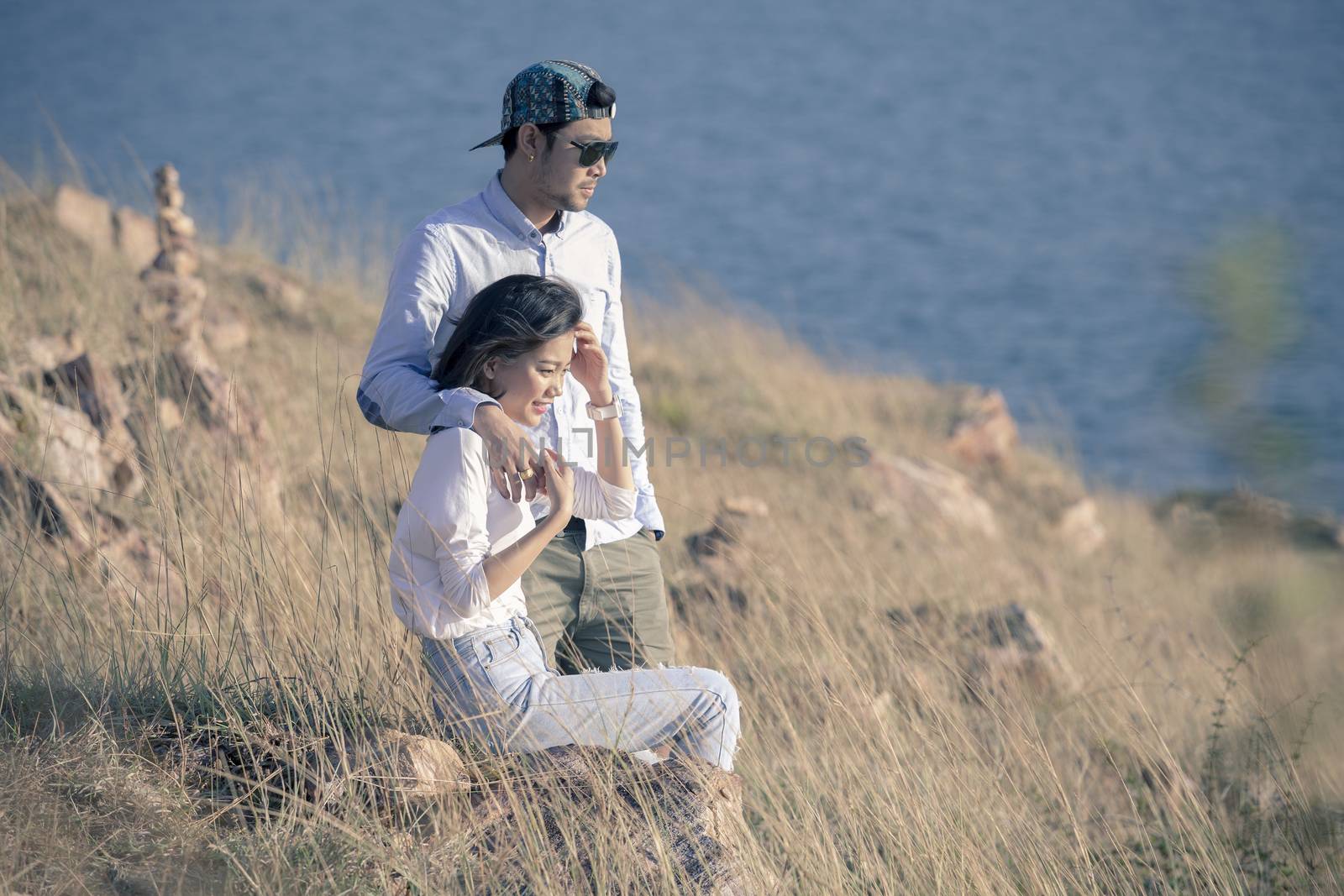 portrait of asian younger man and woman relaxing vacation at sea by khunaspix