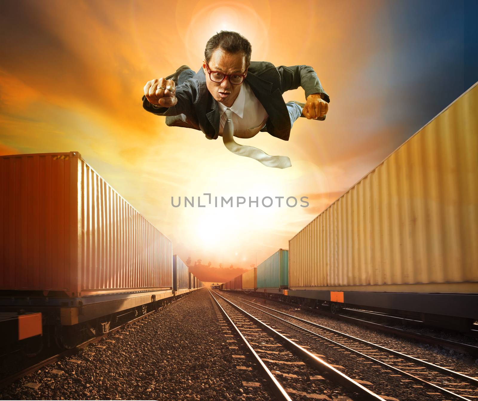 business man flying and industry container trainst running on railways track against beautiful sun set sky use for land transport and logistic business 