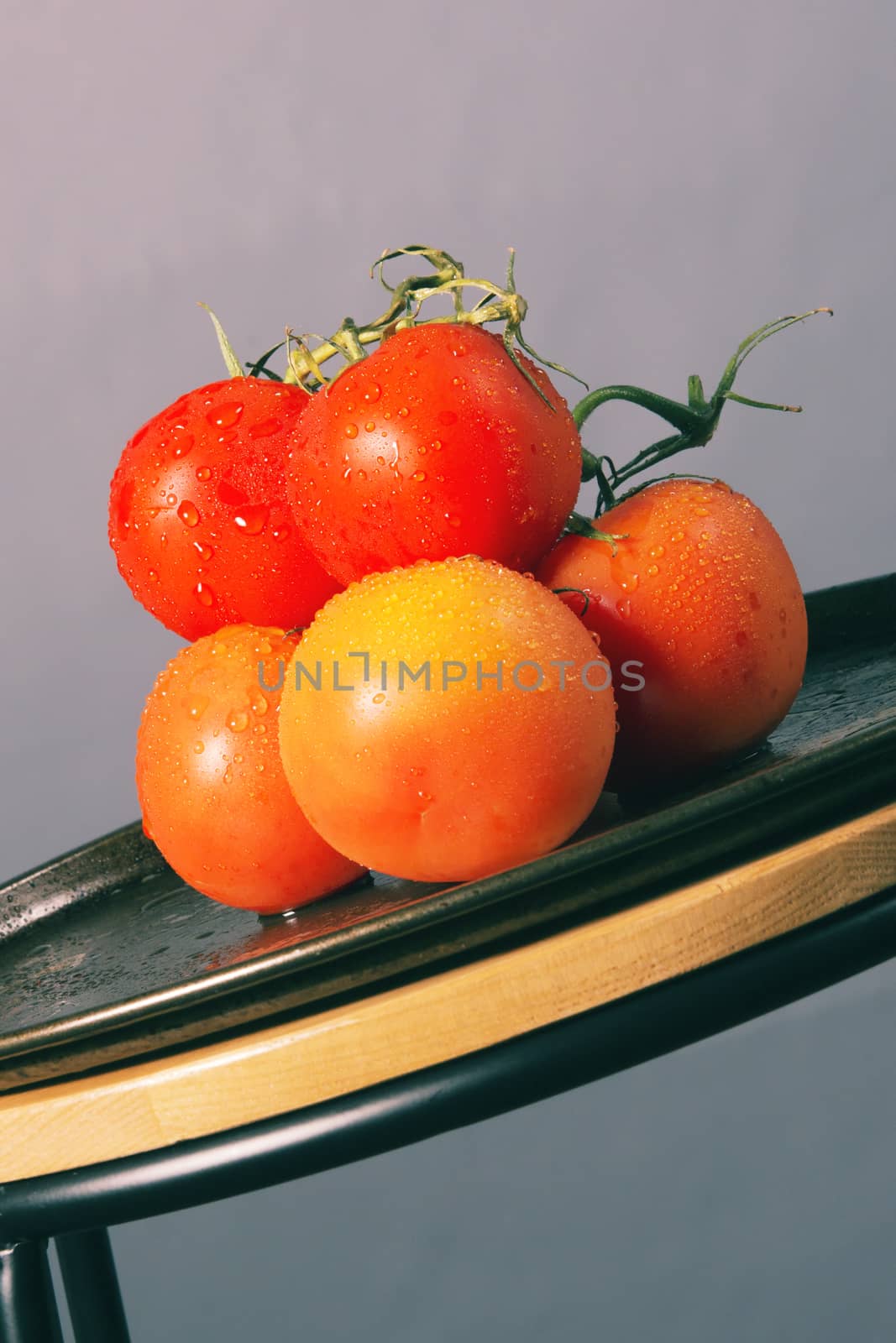 Red ripe fresh tomatoes on a metal baking tray.