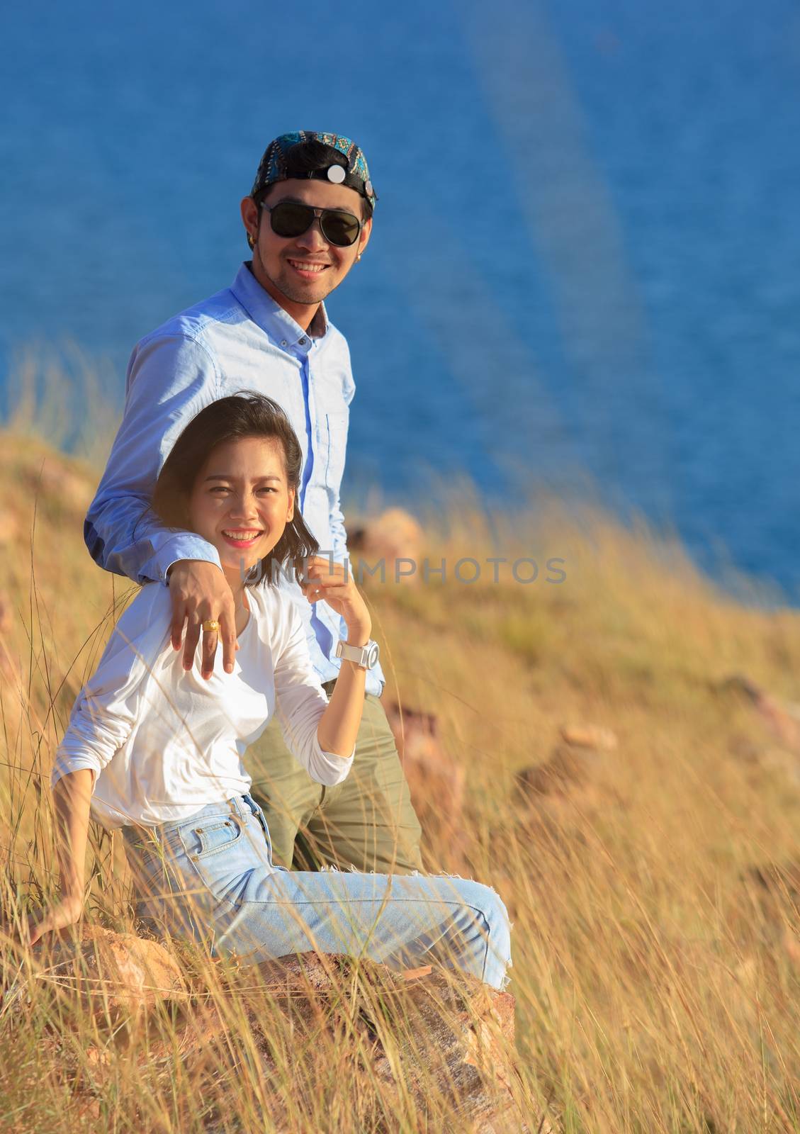 portrait of asian younger man and woman relaxing vacation at sea by khunaspix