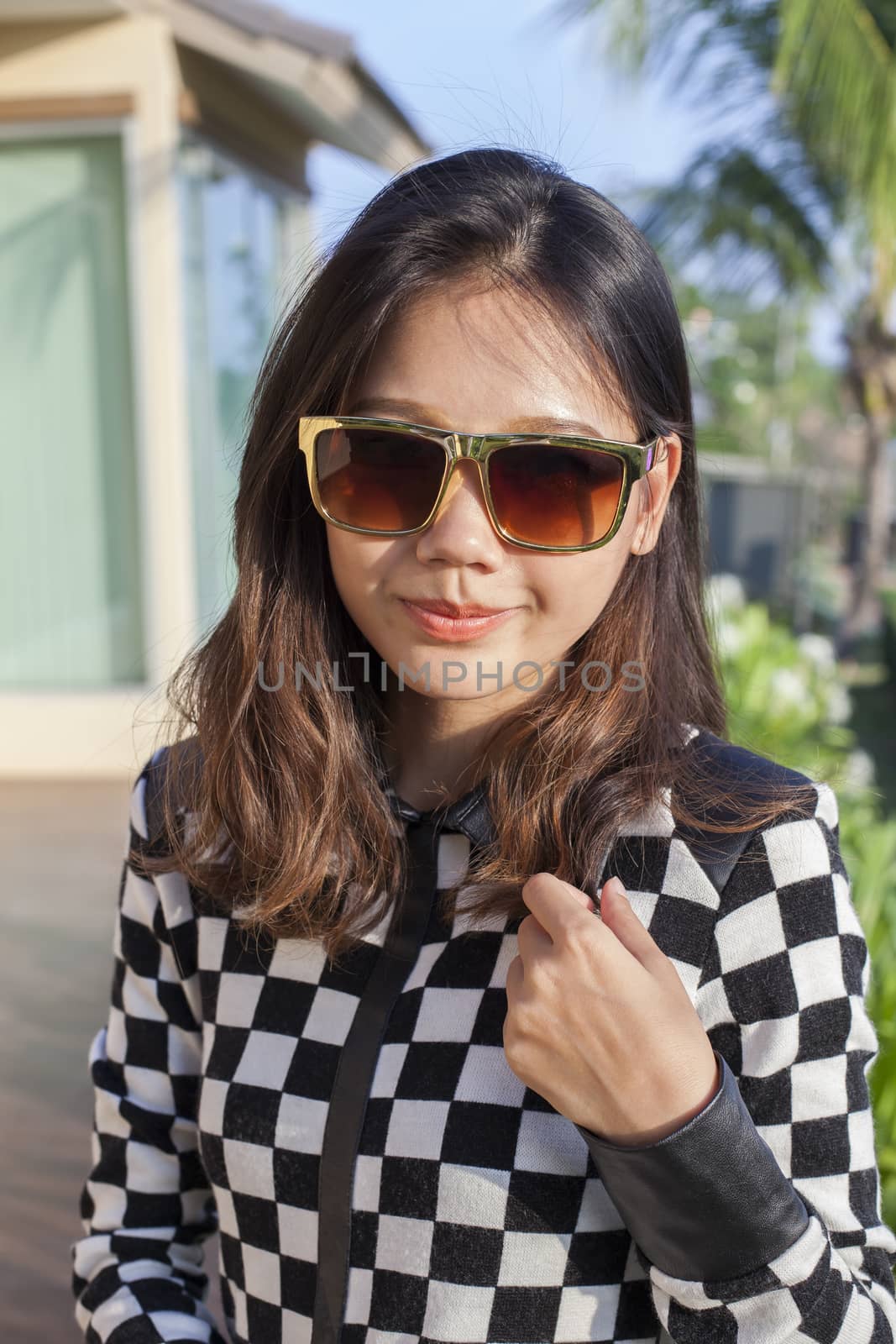 portrait of beautiful chick fashion woman wearing sun glasses against afternoon light with blur background and copy space