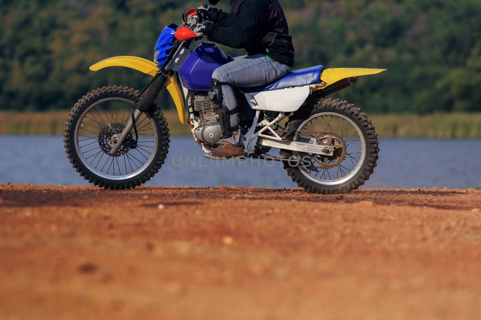 man riding enduro motorcycle on dirt field