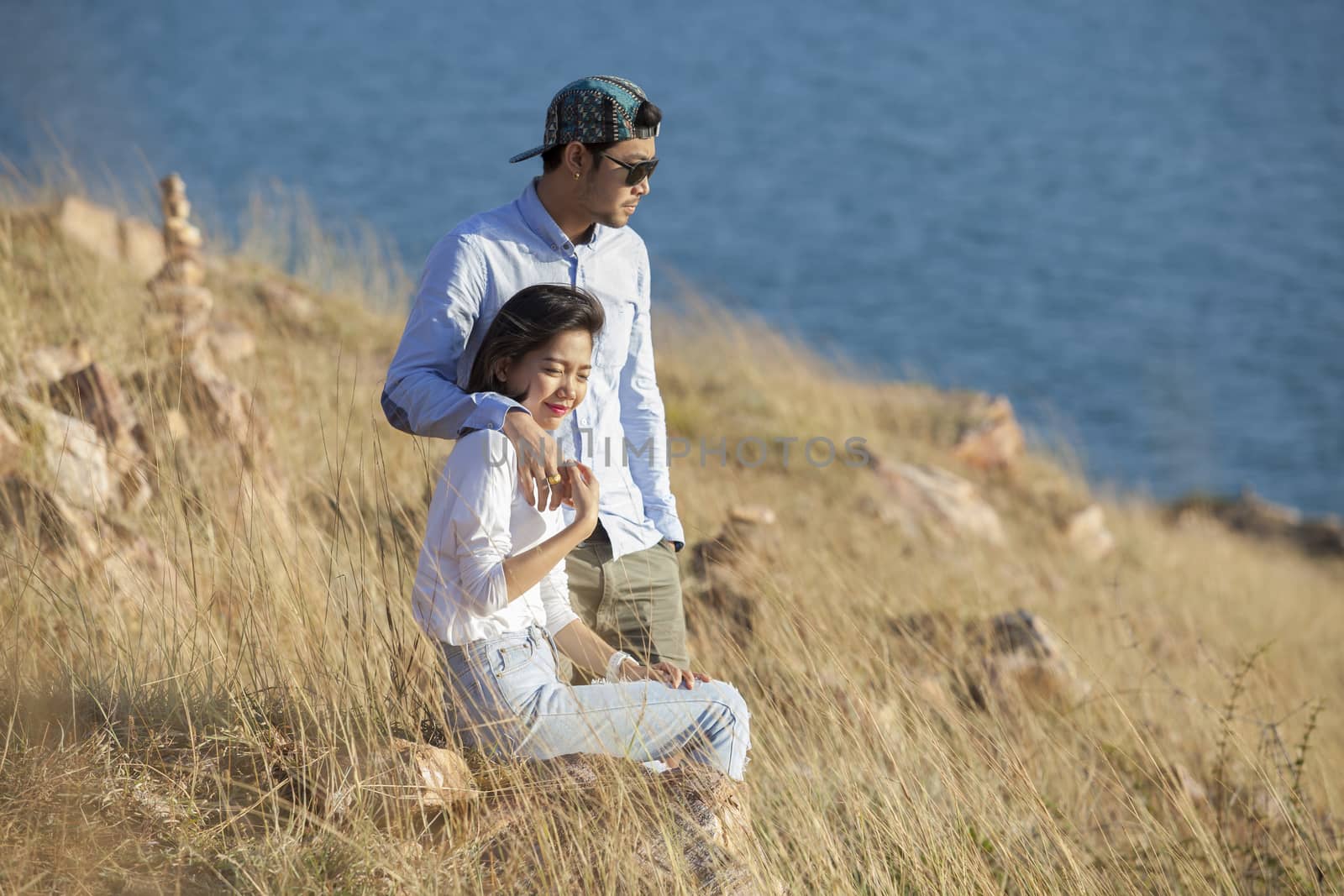 portrait of asian younger man and woman relaxing vacation at sea by khunaspix