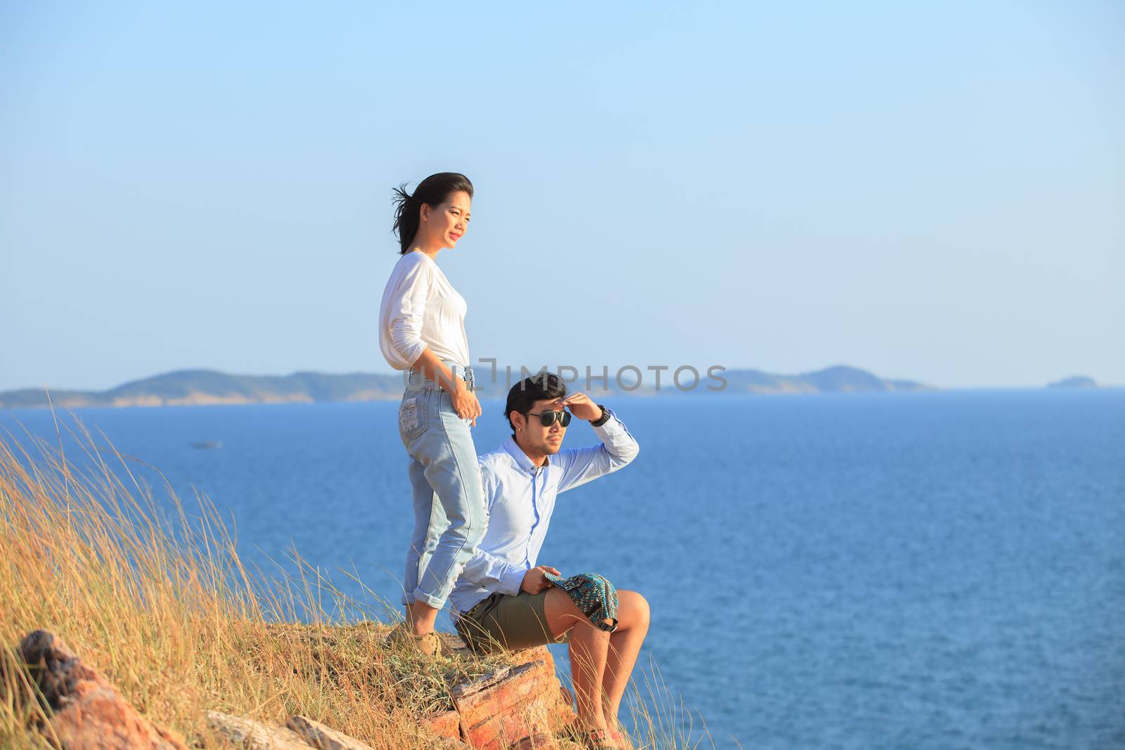 portrait of asian younger man and woman relaxing vacation at sea by khunaspix