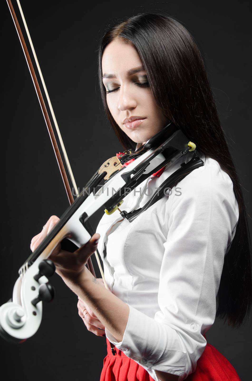 beautiful girl in the playing on violin, black background