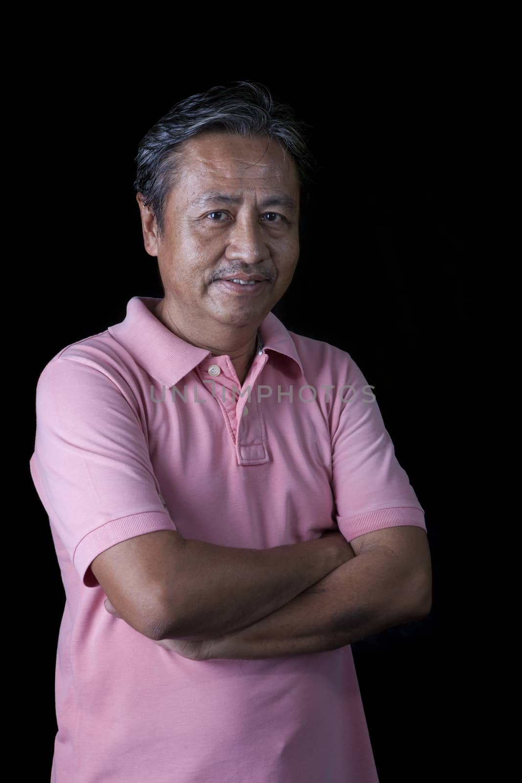 portrait close up smiling happiness face of 59s years old asian man with studio light against black background