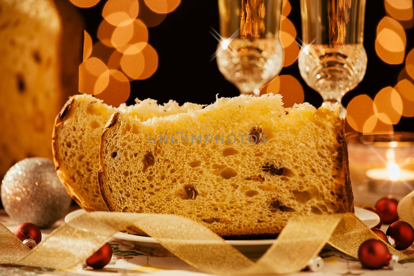 Closeup of sliced italian panettone and sparkling wine with decorations