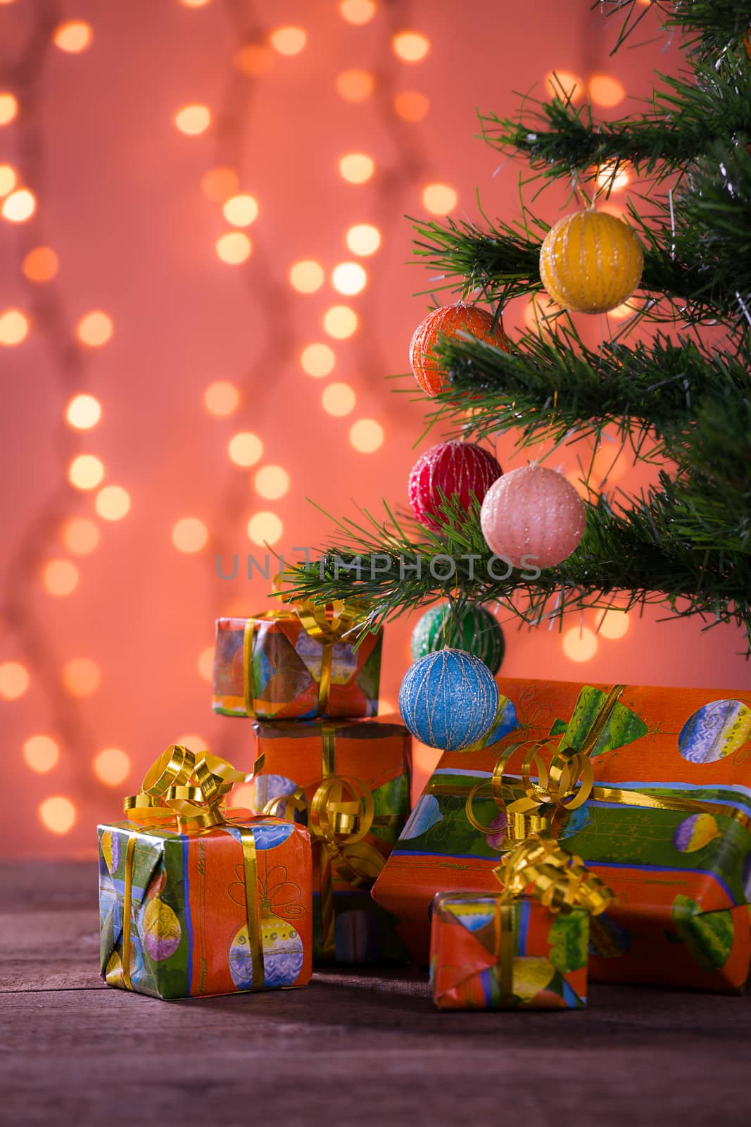 Christmas gifts with blurred lights on background over the planks under the tree