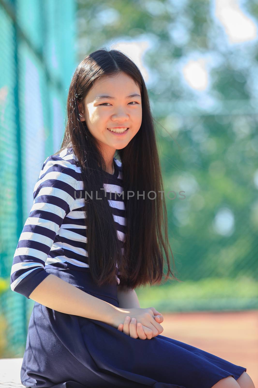 portrait happy face of asian girl toothy smiling happiness emotion in outdoor sport field