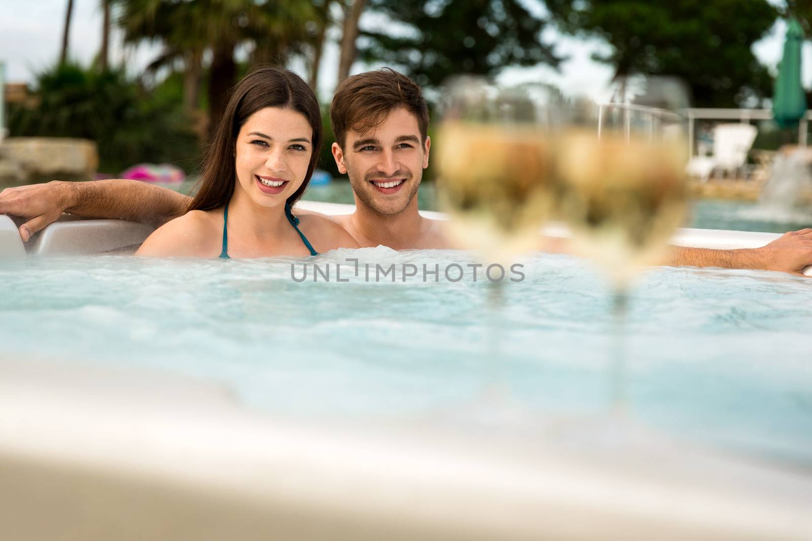 Young couple inside a jacuzzi and tasting wine