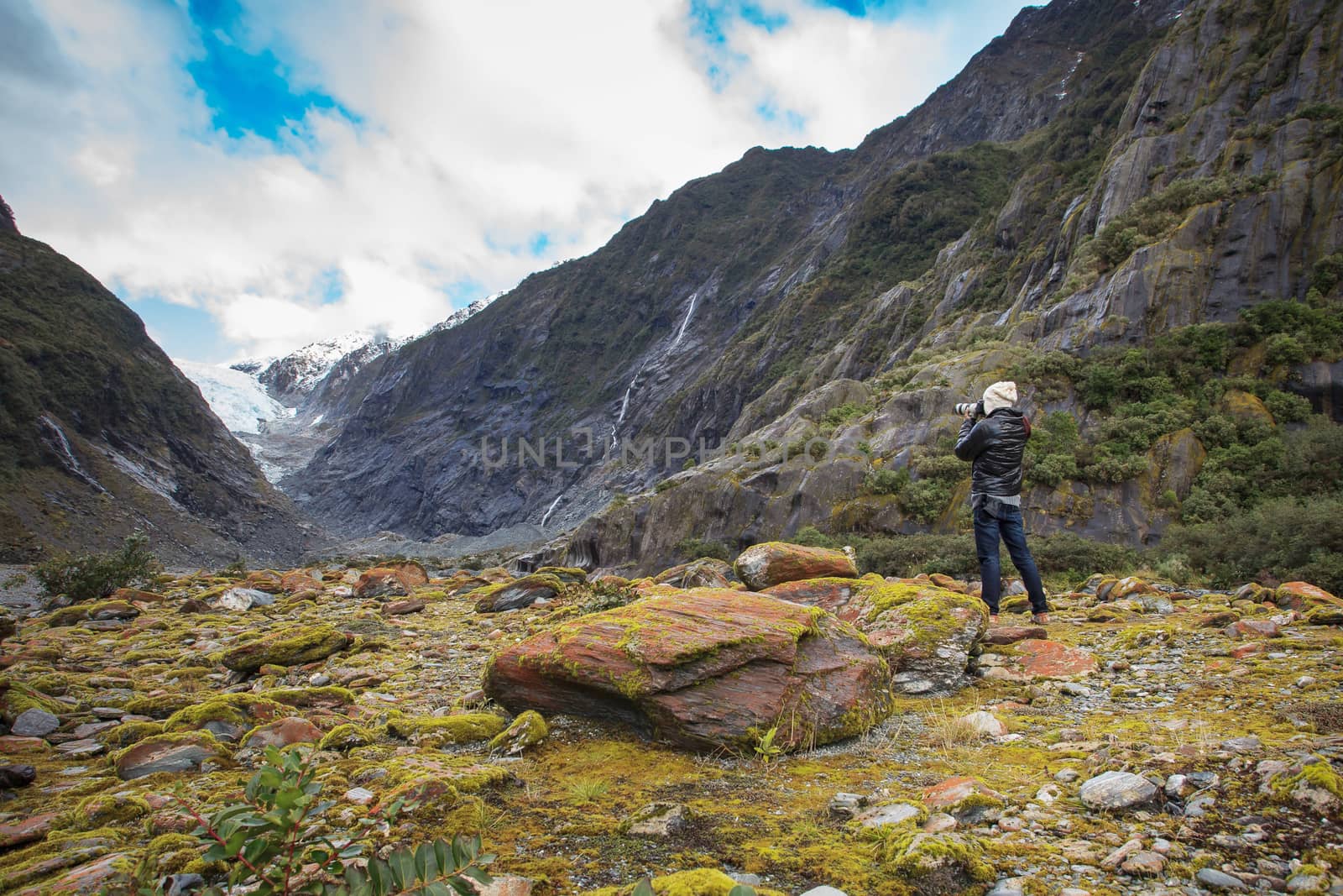 photographer taking a photo in franz josef glacier in south island new zealand importanat natural traveling destination