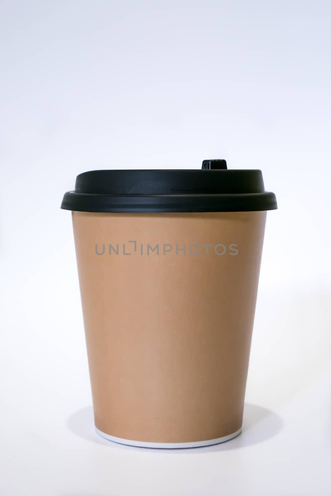 The brown paper cup of hot coffee with black cap.