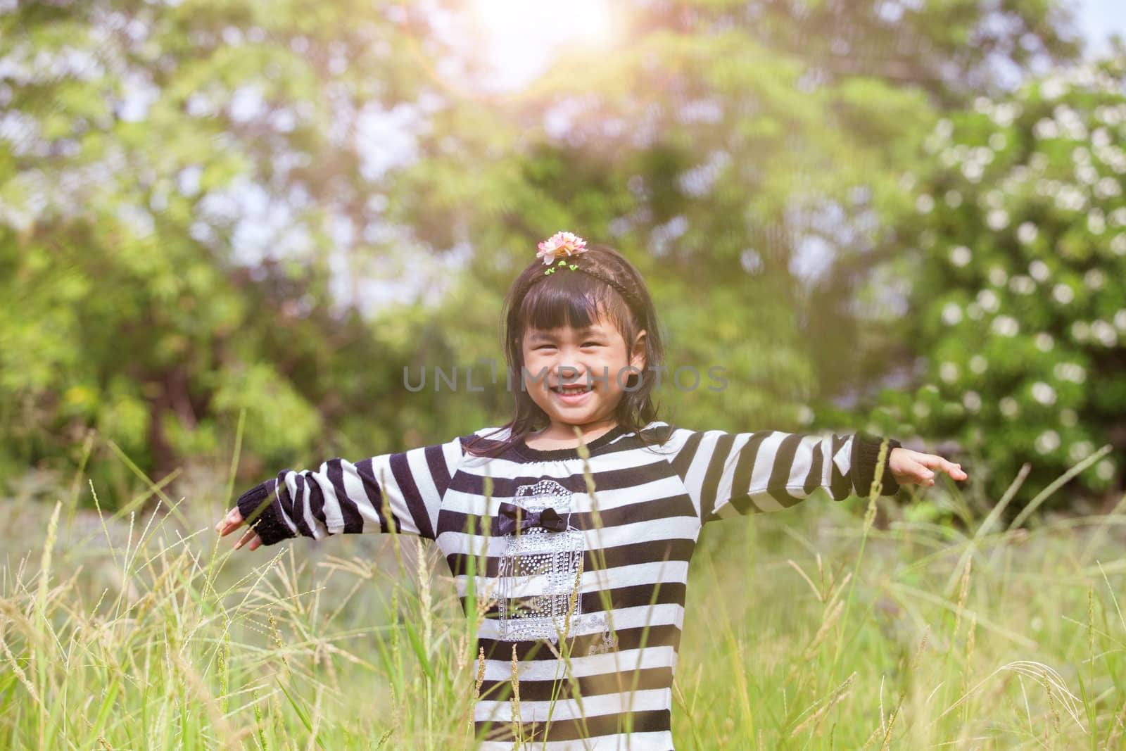 lovely kid smiling face with happiness emotion in natural green field 