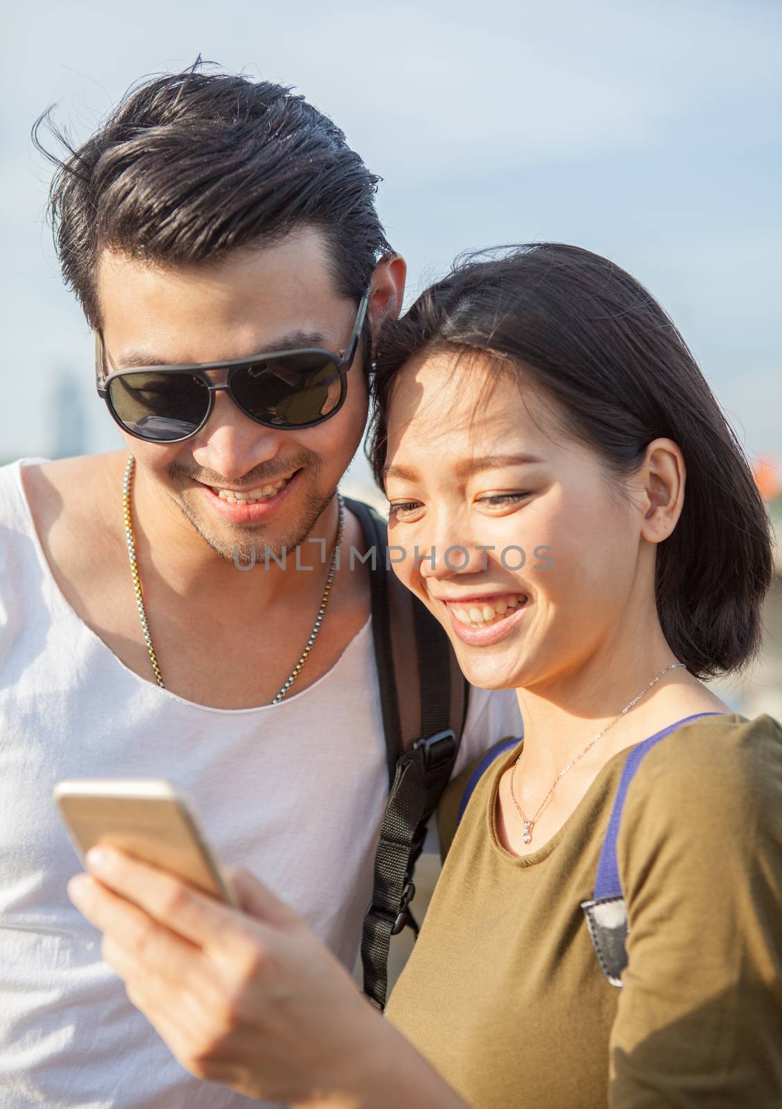 close up face of younger asian man and woman looking to smart phone use for young people digital technology lifestyle