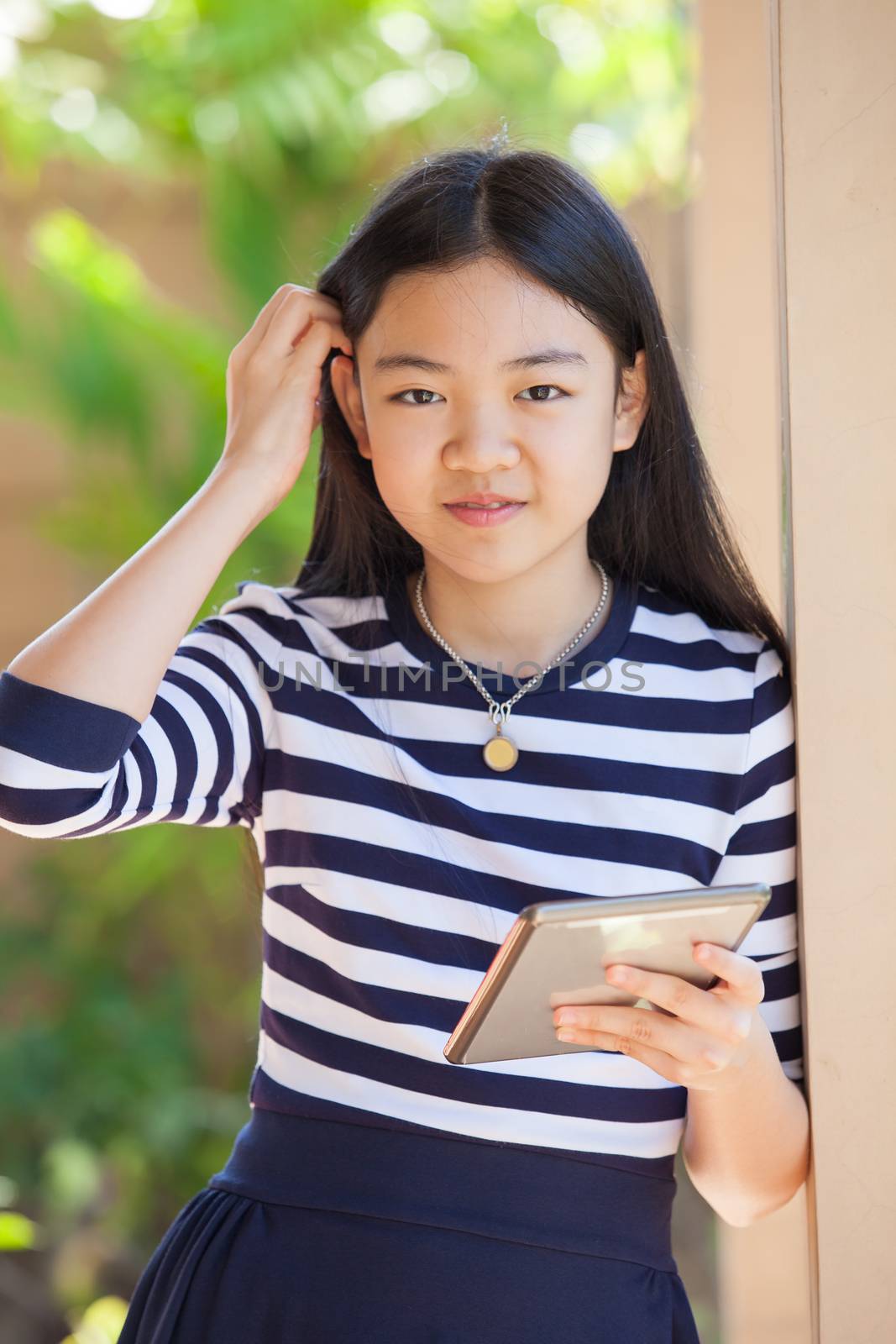 portrait of asian teen age ,girl with computer tablet in hand standing with happiness and relax emotion outdoor use for modern digital lifestyle