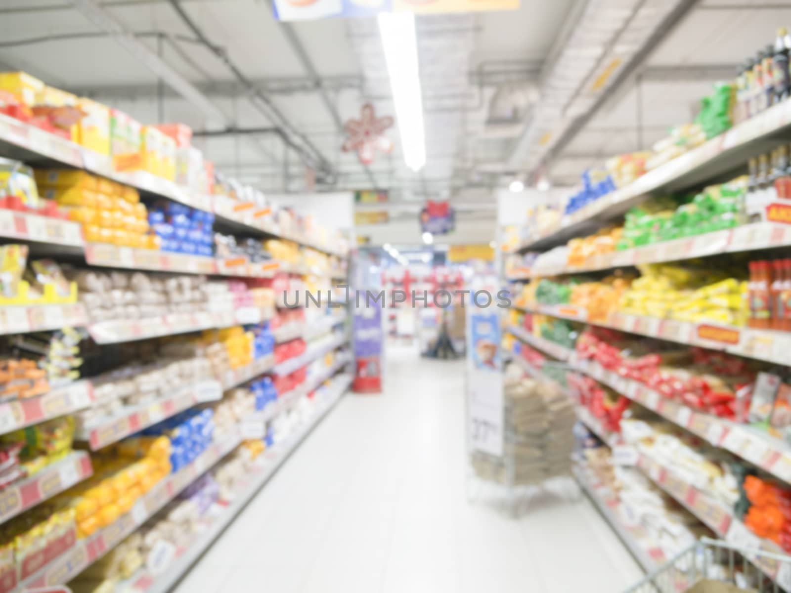 Abstract blurred supermarket aisle with colorful shelves and unrecognizable customers as background by fascinadora