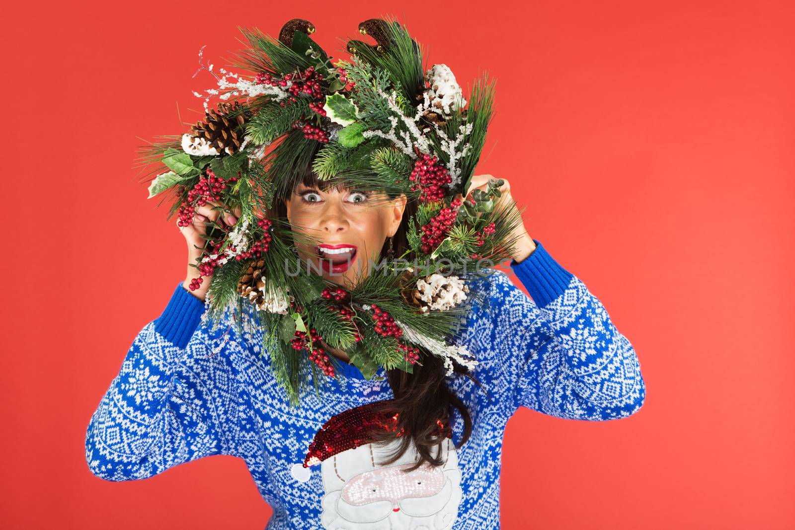 Woman looking through Christmas wreath by Creatista