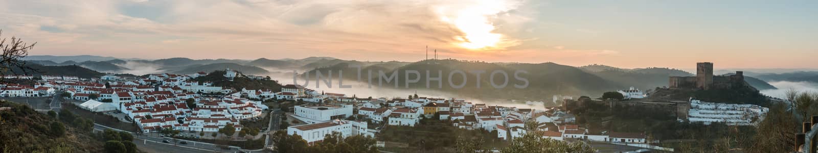Wide view of Mertola village engulfed on a foggy morning.