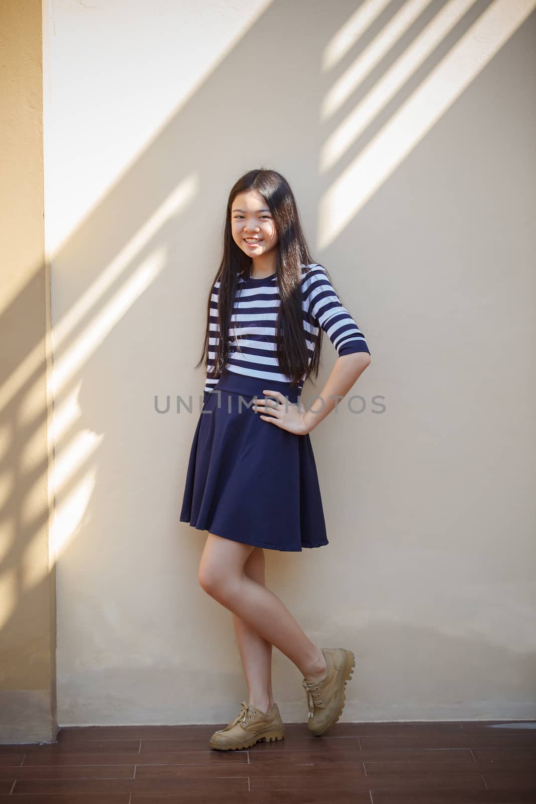 portrait of asian teen age smiling face standing at home with relax and happy emotion