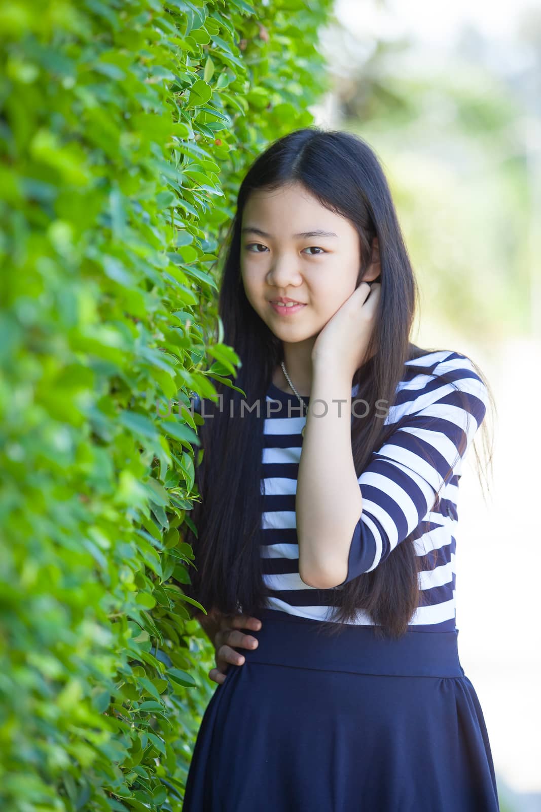 portrait of younger asian teen with happiness emotion and smiling face in green park