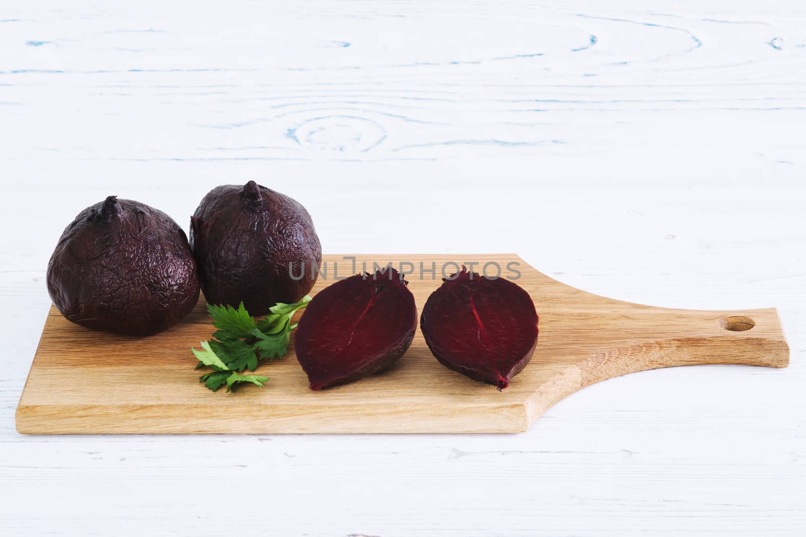 Boiled beets on board, light wooden background