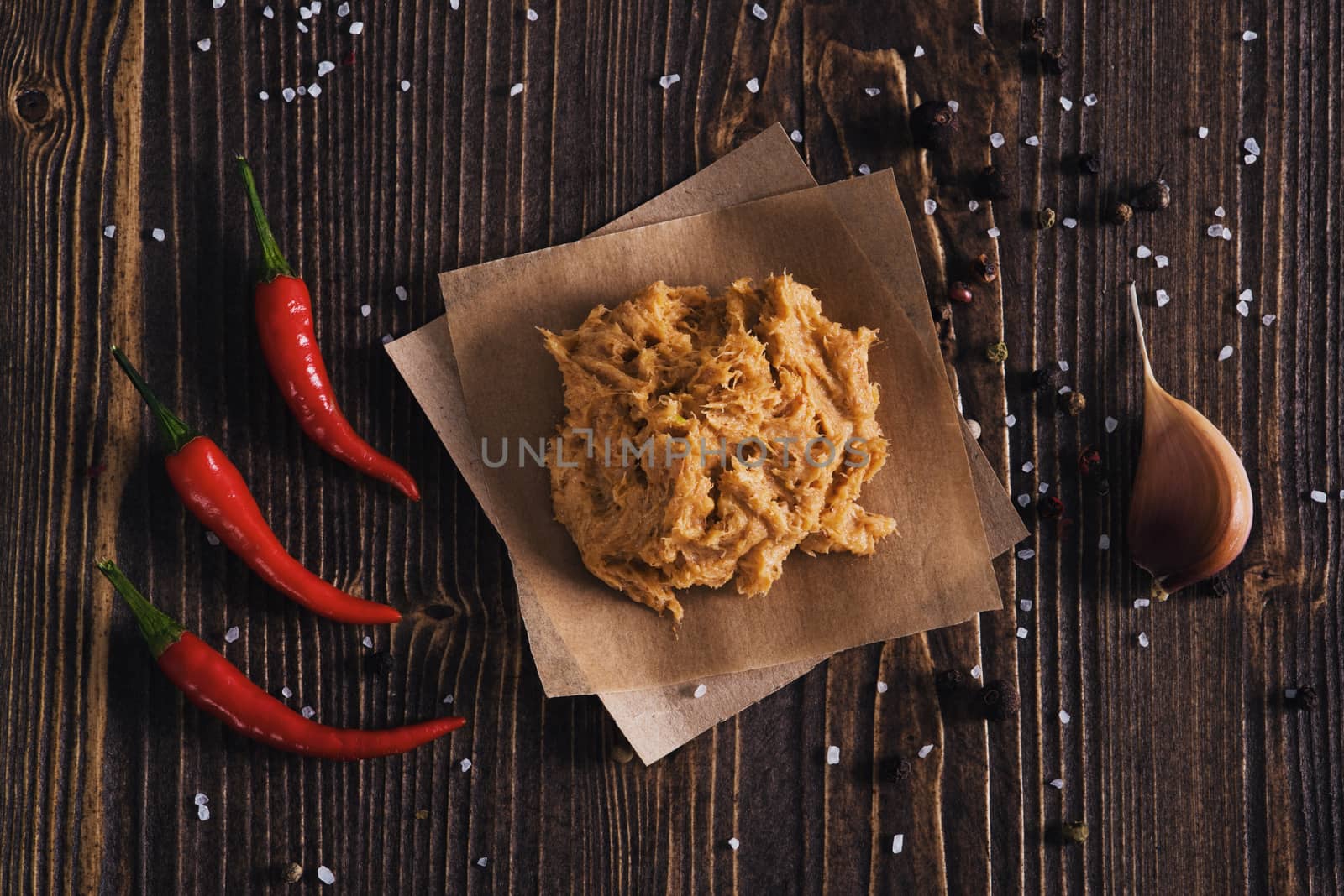 Lard with salt, chili pepper and garlic, wooden background