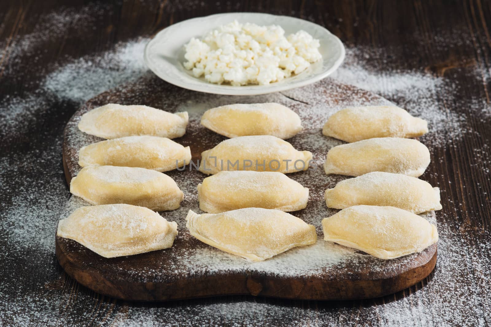 Raw dumplings with cottage cheese on the board