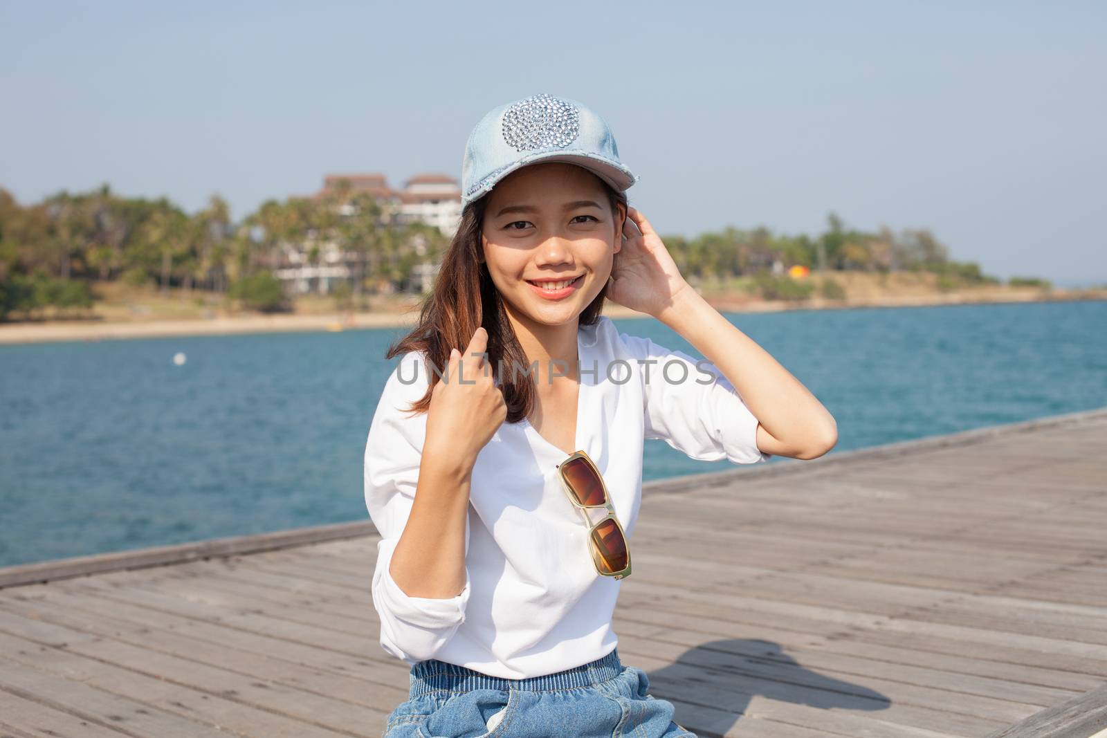 portrait of beautiful woman happy face sitting on wood port sea side use for people activities holiday ,vacation on beach