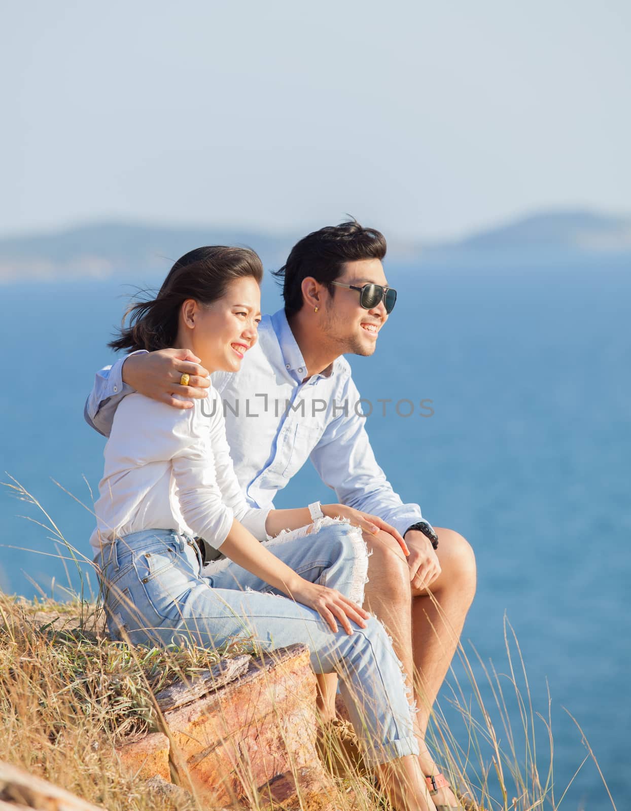 portrait of asian younger man and woman relaxing vacation at sea by khunaspix