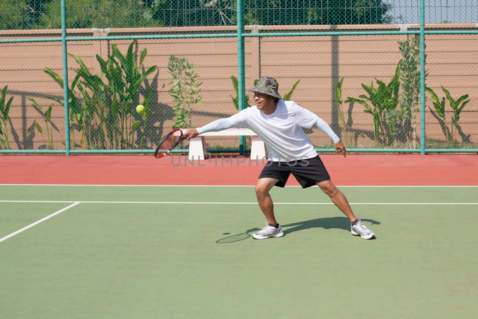 senior 59s years old man playing tennis in sport club