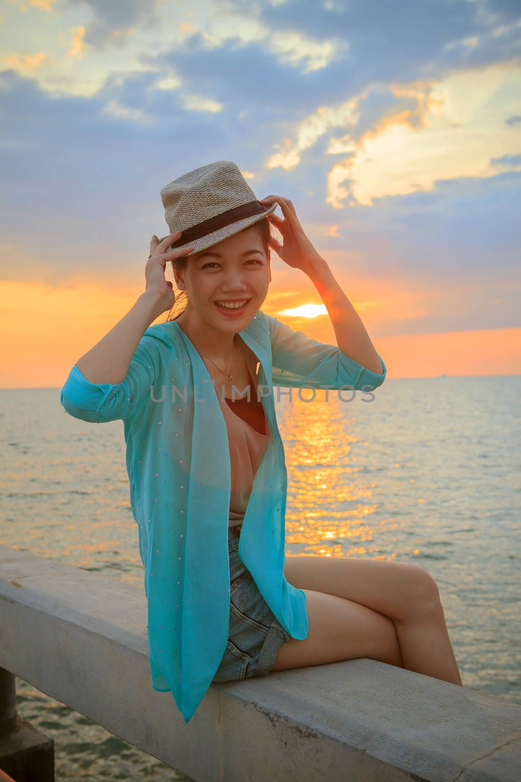 portrait of young beautiful asian woman laughing and  relaxing with happy emotion at sea side