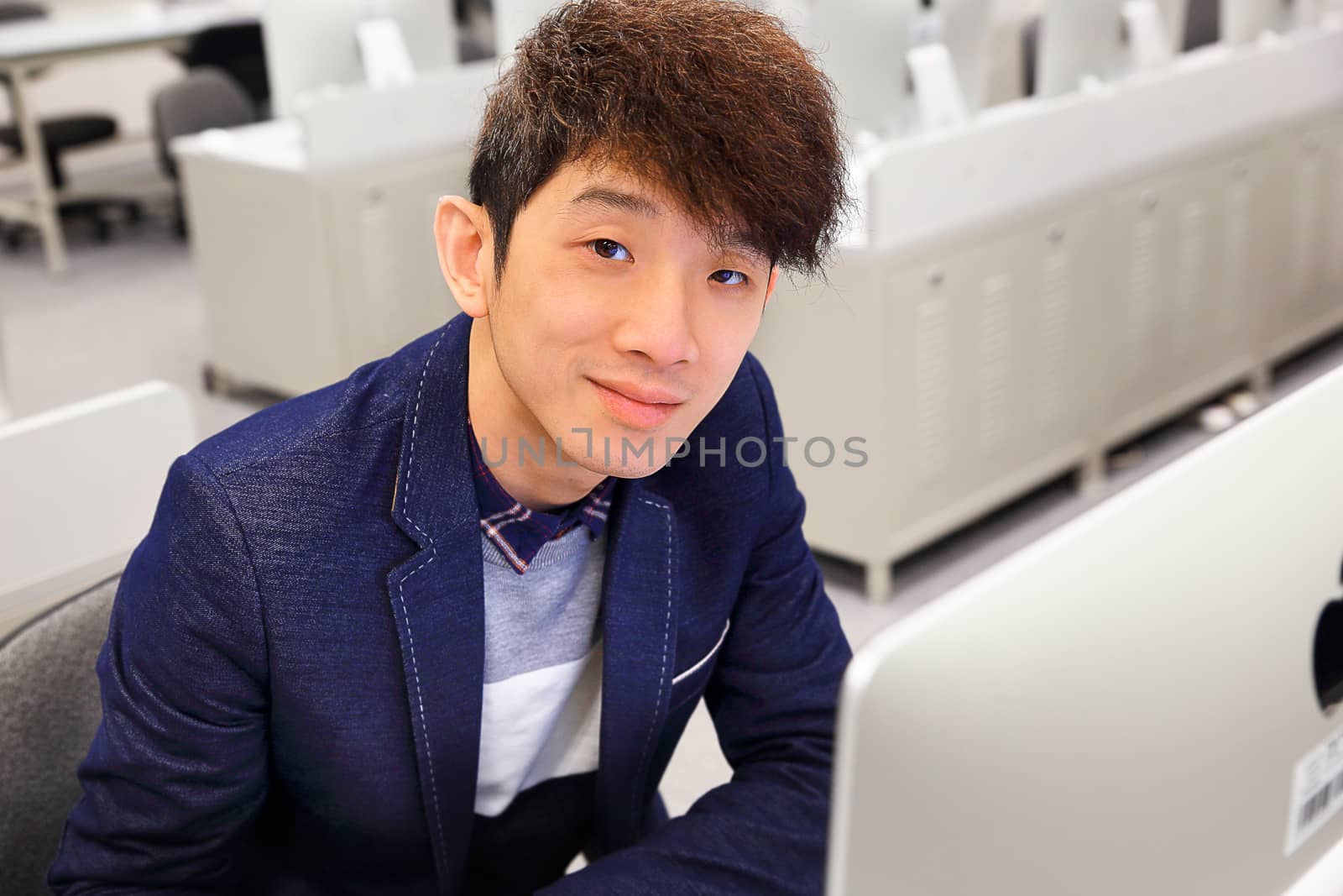 young asian man using computer in classroom