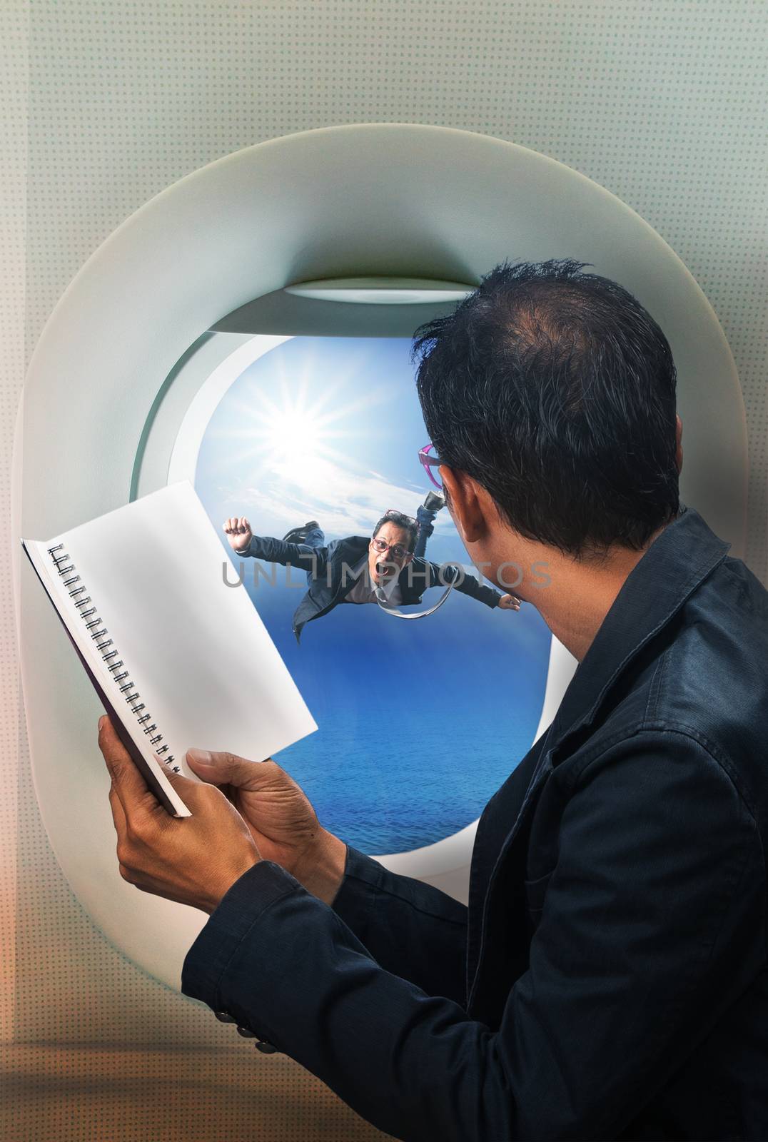 business man reading book in passenger plane seat and looking to out side of plane see another buseness man flying beside a window