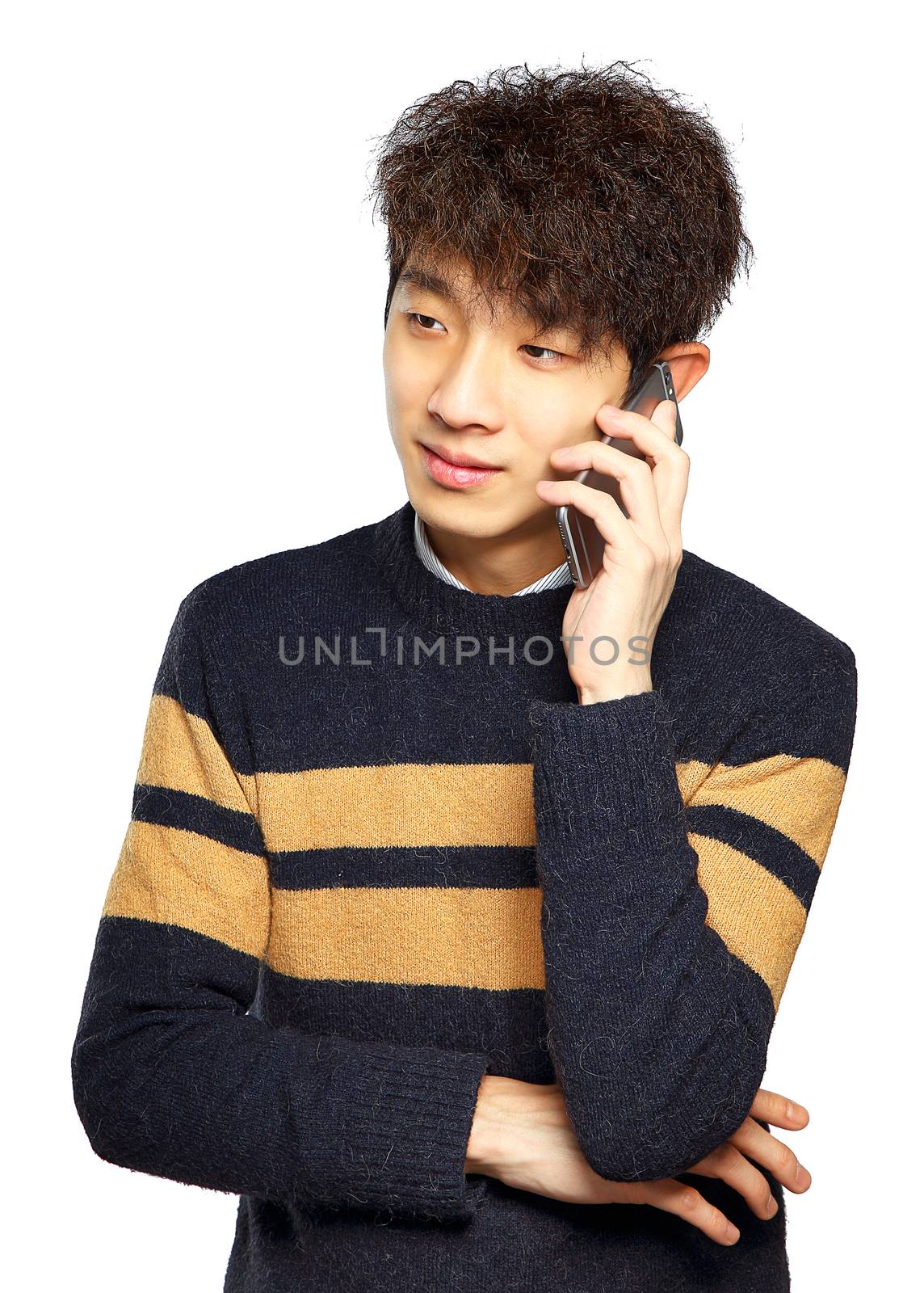 Happy young man talking on mobilephone, smiling happy, looking away.