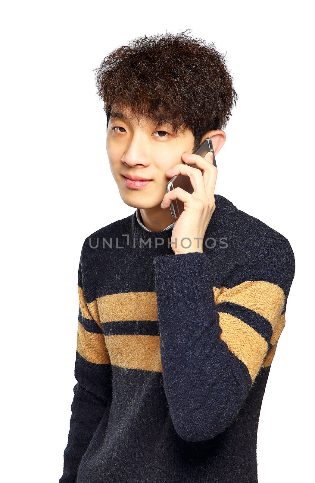 Happy young man talking on mobilephone, smiling happy, looking at camera.