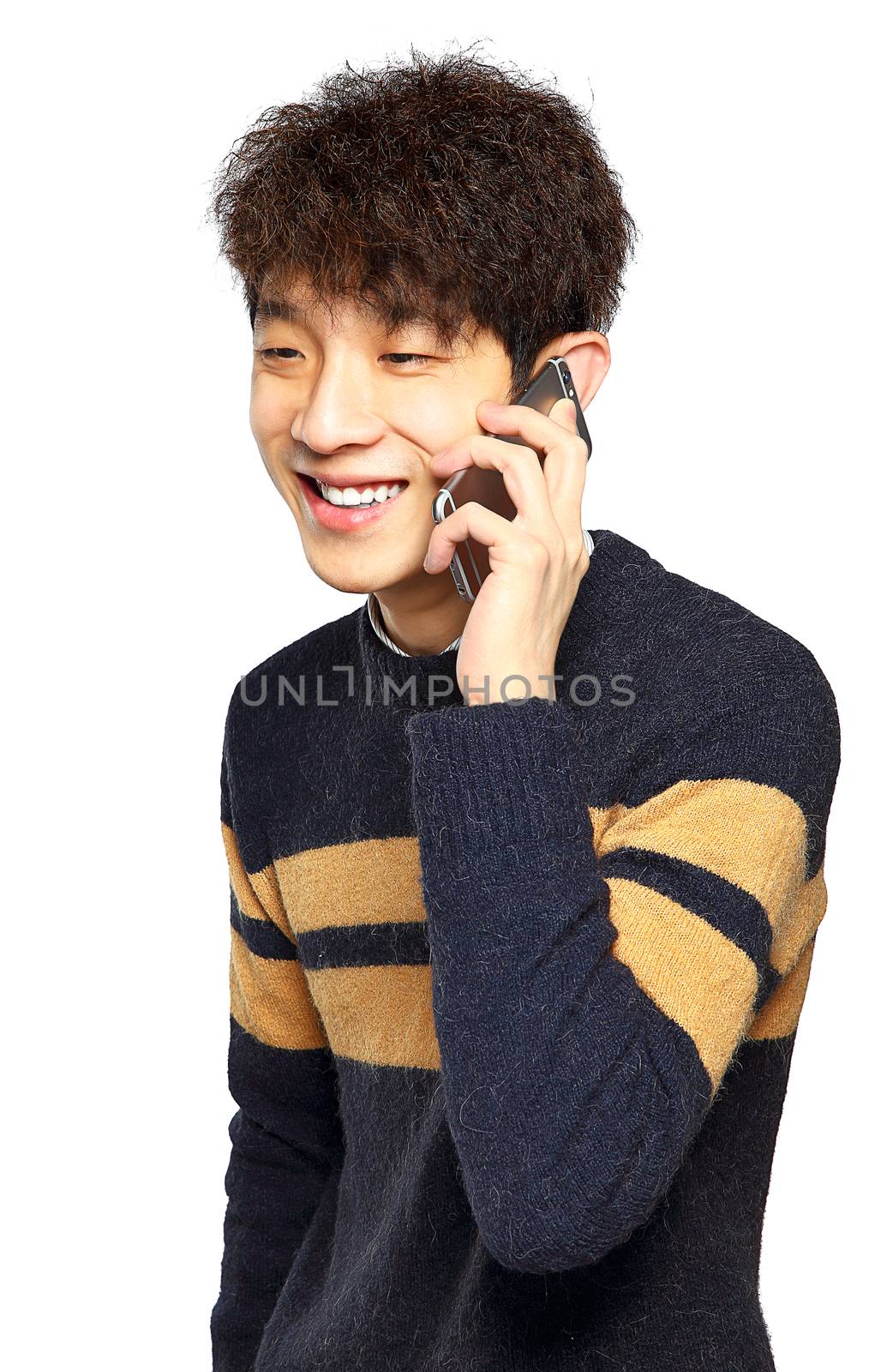 Happy young man talking on mobilephone, smiling happy, looking away.