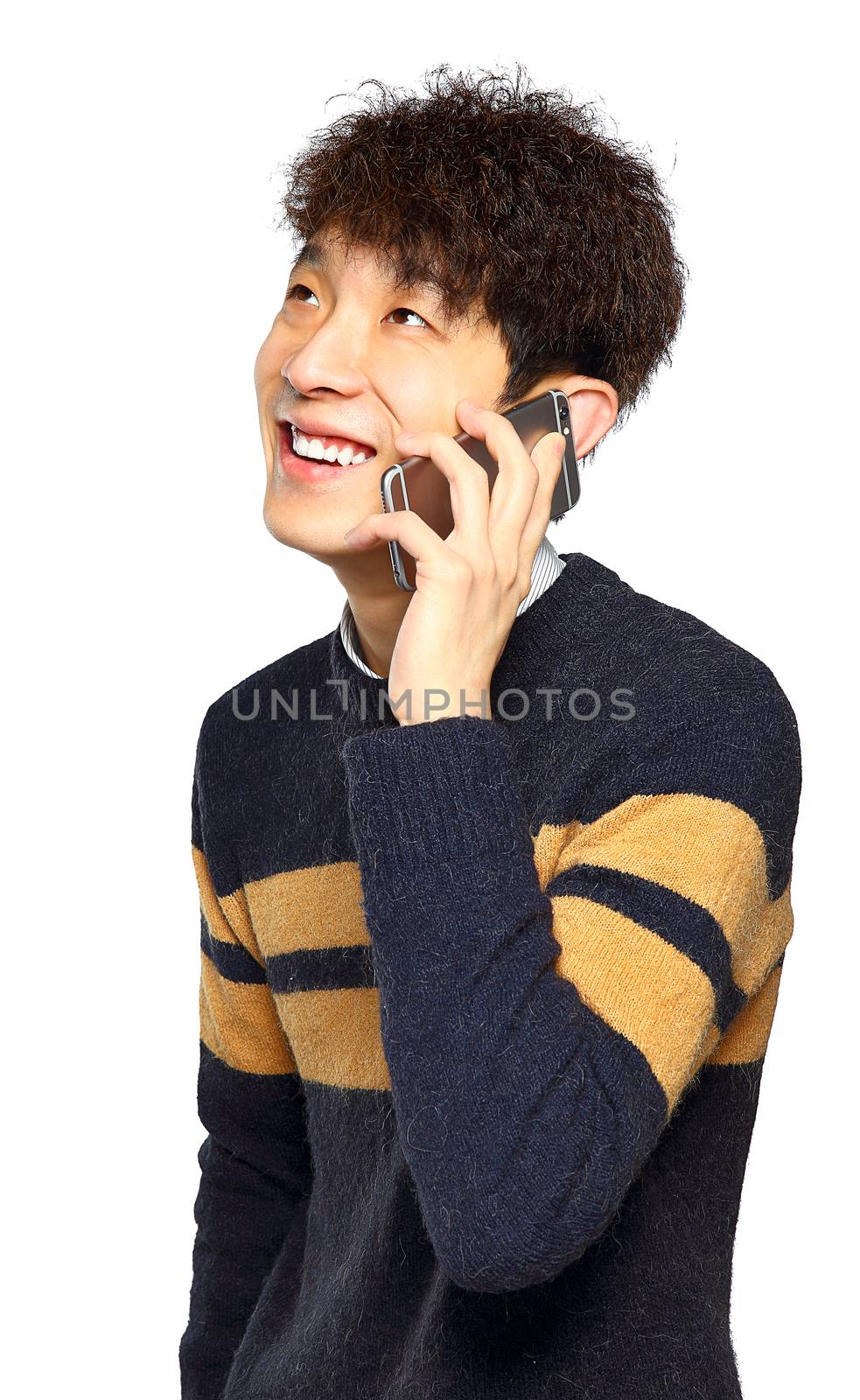 Happy young man talking on mobilephone, smiling happy, looking away.