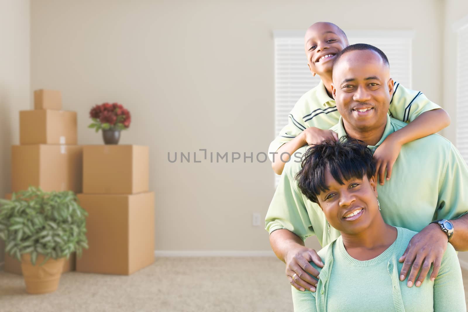 African American Family In Room with Packed Moving Boxes by Feverpitched
