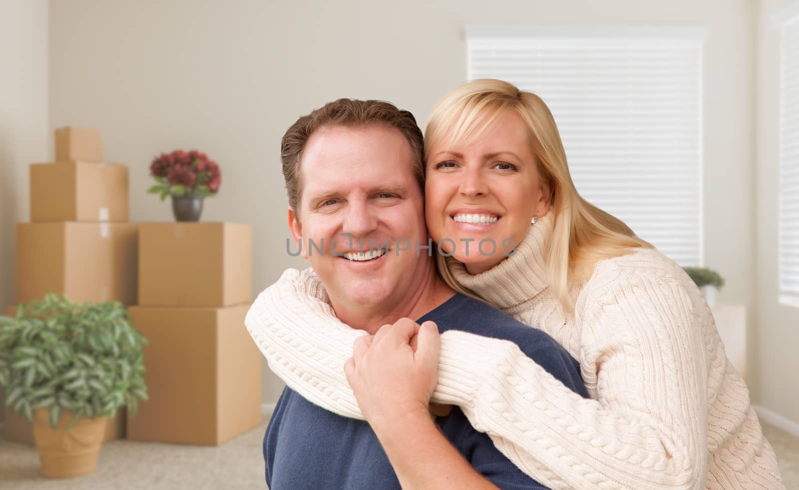 Young Couple in Empty Room with Packed Boxes by Feverpitched