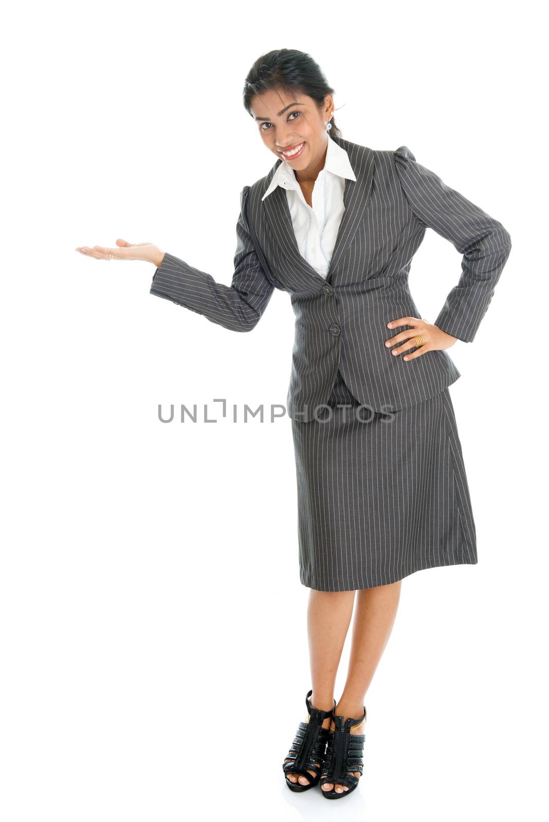 Full length portrait of Indian businesswoman hand showing something, standing isolated on white background. 