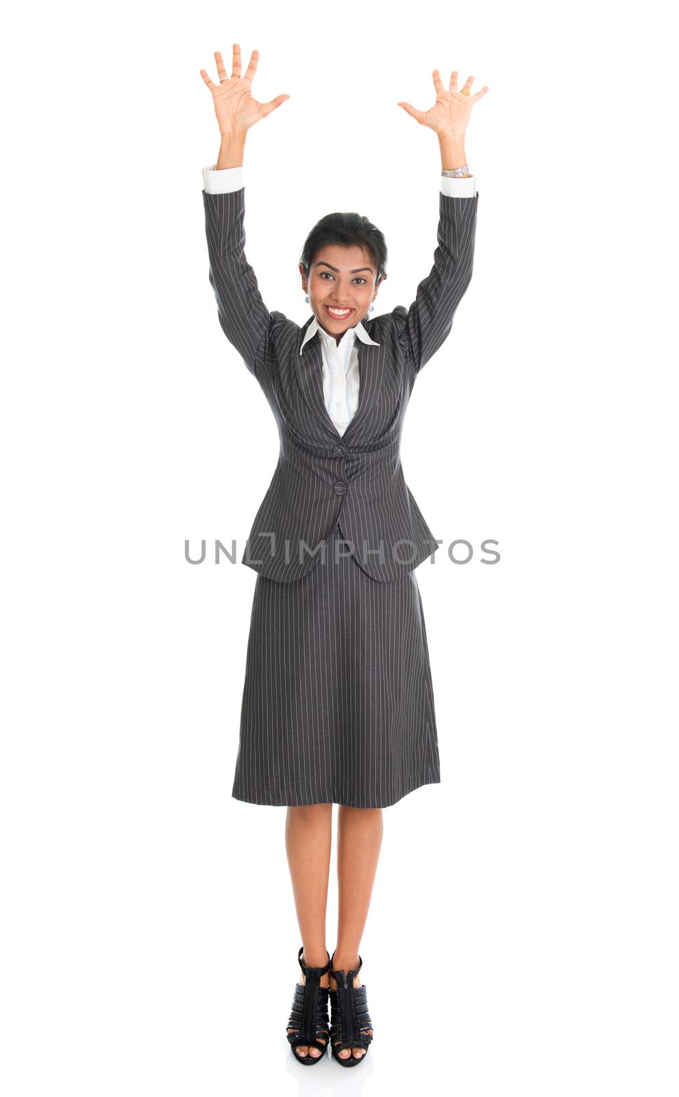Full length portrait of Indian businesswoman arms raised, standing isolated on white background. 