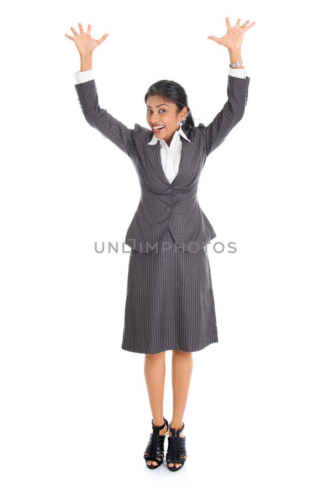 Full length portrait of excited Indian business woman arms raised, standing isolated on white background. 