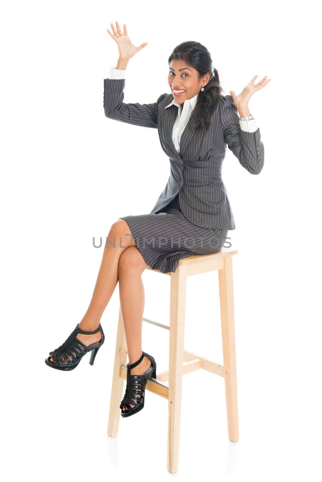 Happy full body black businesswoman sitting on high chair and hands raised,  isolated on white background.