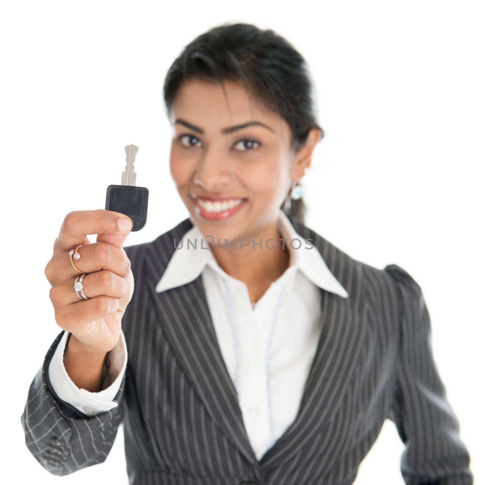 Car dealer hand holding vehicle key and smiling, isolated on white background.