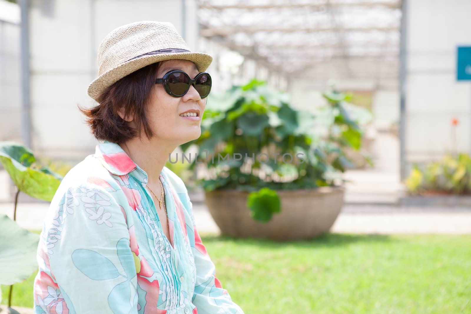 portrait head shot face of asian woman with sun glasses and straw hat relaxing outdoor