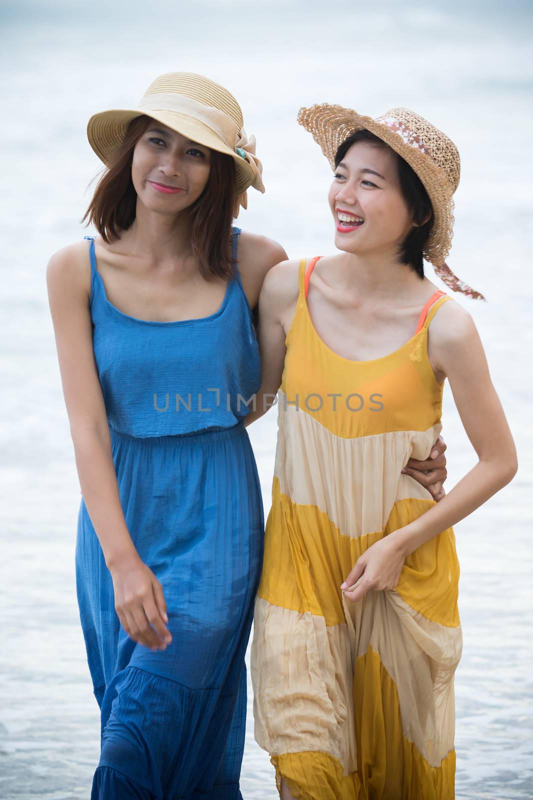 portrait of young asian woman with happiness emotion wearing beautiful dress walking on sea beach and laughing joyful use for people relaxing vacation on destination